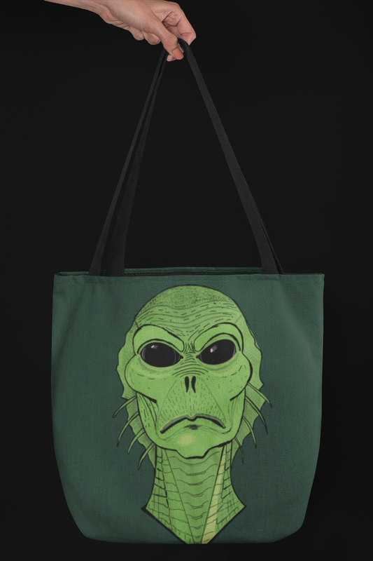Hunter green tote bag with black straps held by a hand against a black background, featuring the green Swamp Thang creature face