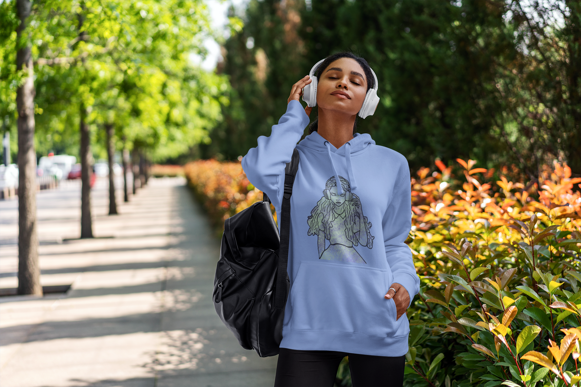 Woman standing outside wearing Carolina blue Gildan hoodie featuring That Girl, Alice grunge-cute Wonderland design. Bold, whimsical, and full of attitude for the curious ones.