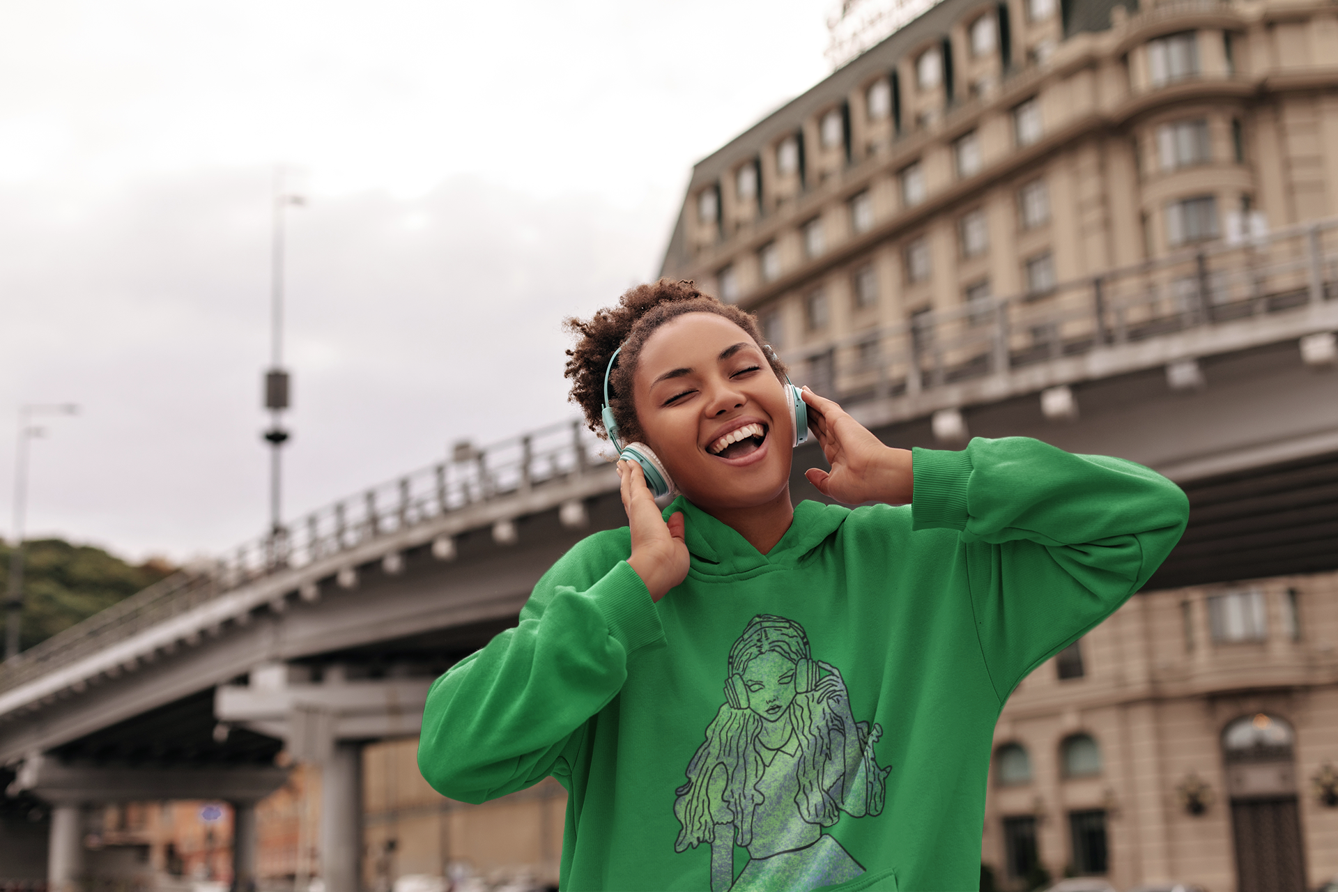 Woman listening to music wearing Irish green Gildan hoodie with That Girl, Alice grunge-cute Wonderland design. Whimsical, edgy, and self-taught art for the dreamers who know the real adventure.