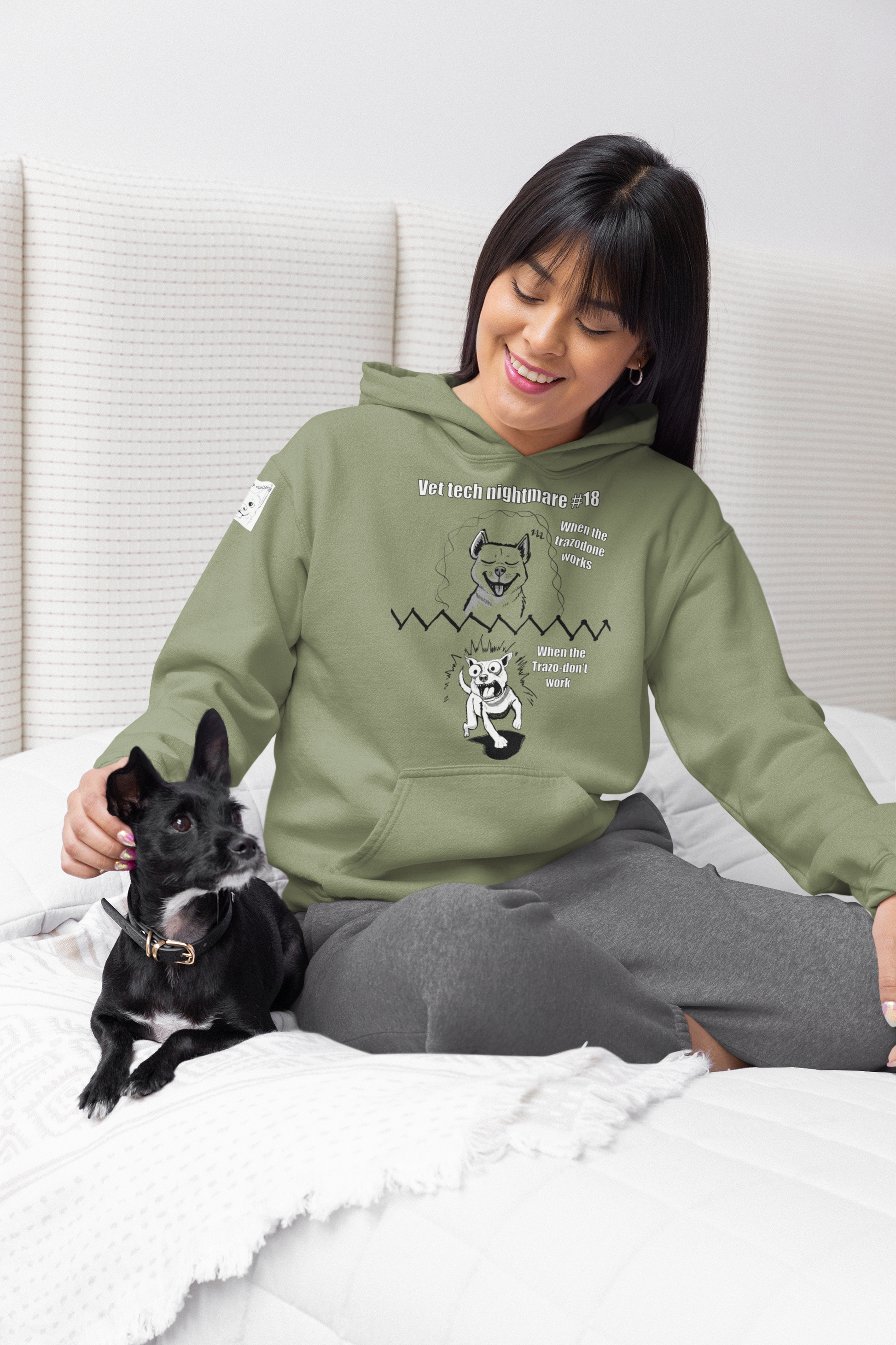 Woman petting her dog while wearing a military green Gildan 18500 hoodie displaying Vet Tech Nightmare #18 with the happy dog and demonic dog panels.