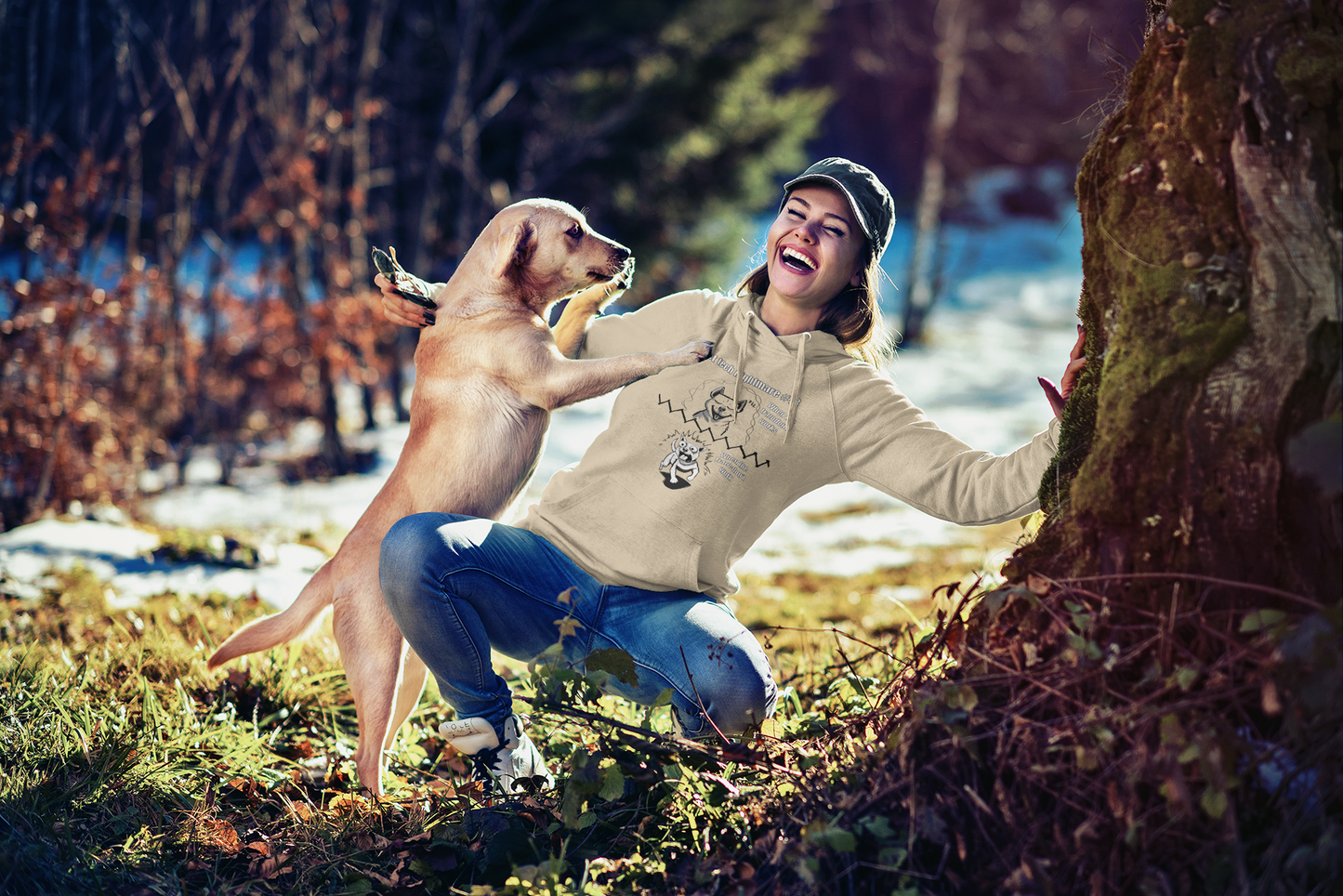 Smiling woman in a sand-colored Gildan 18500 hoodie playfully interacting with a yellow dog in a wooded area, showcasing the full Vet Tech Nightmare #18 split design.