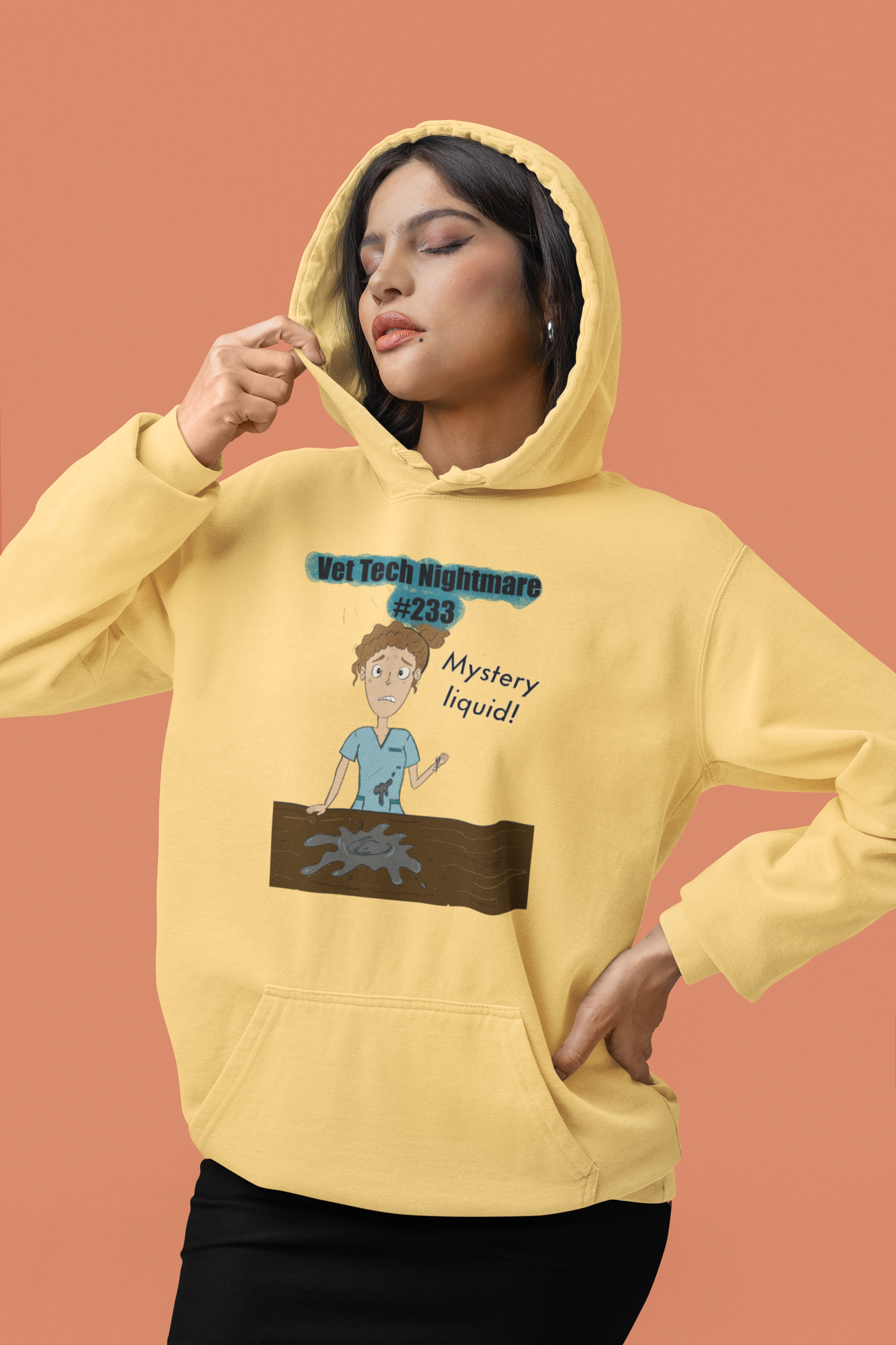 Woman posing in studio wearing butter yellow Comfort Colors hoodie with Vet Tech Nightmare #233 Mystery Liquid design