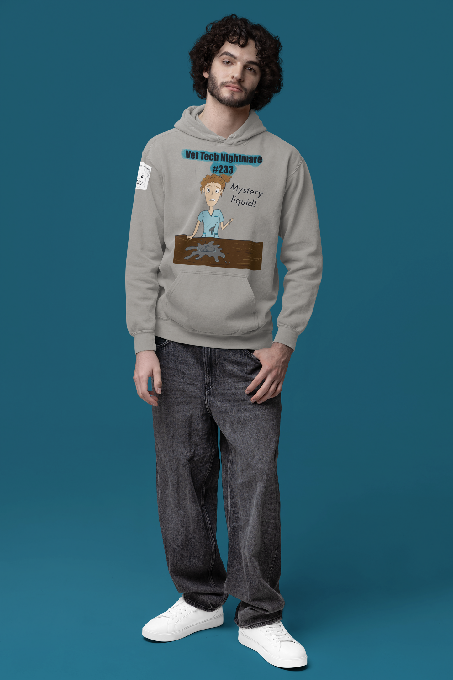 Man standing wearing grey Comfort Colors hoodie with Vet Tech Nightmare #233 Mystery Liquid graphic