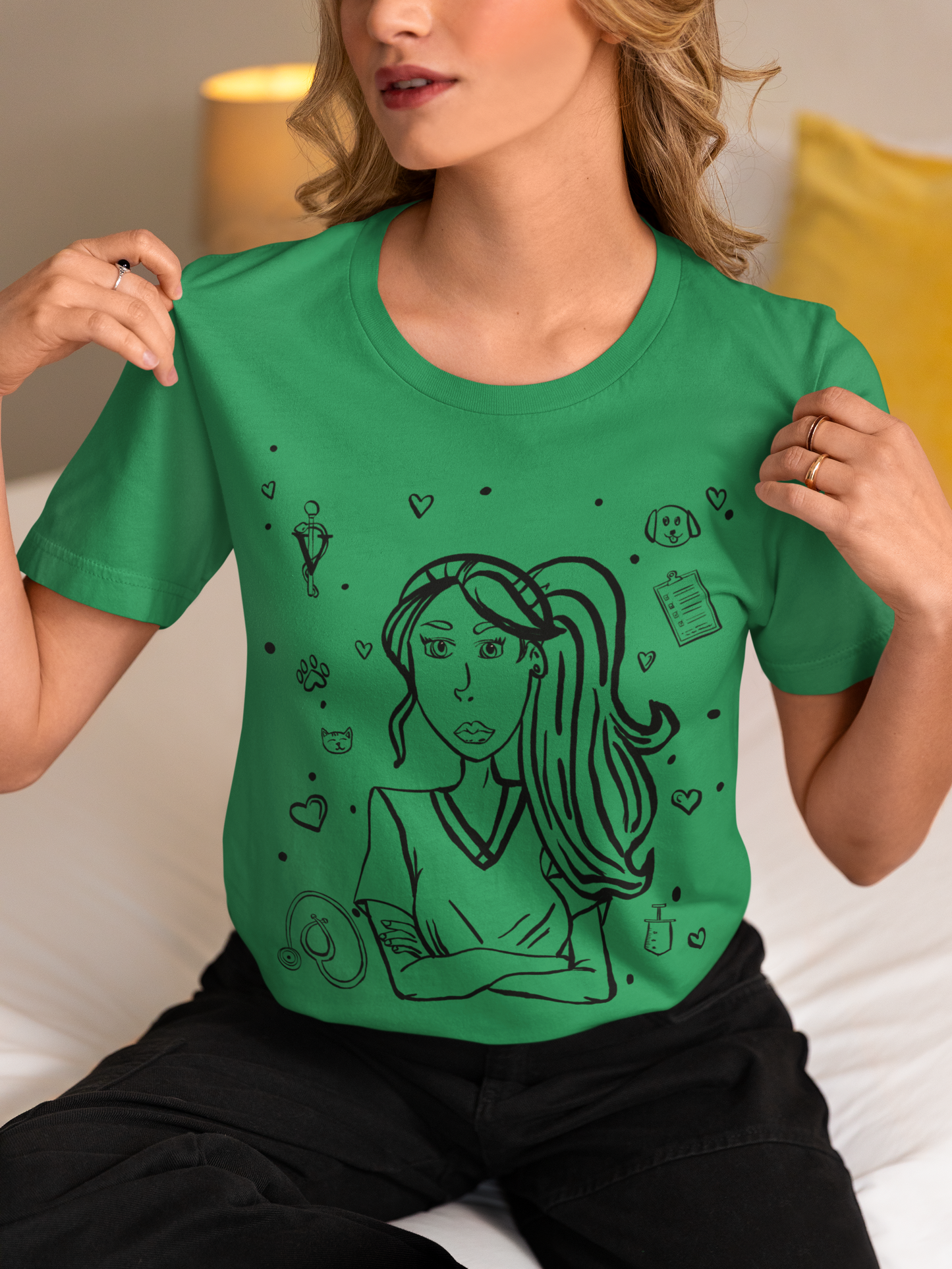 Close-up of a woman with blonde hair sitting on a bed and holding the collar of her kelly green Vet Vibe t-shirt featuring the darkened line-art vet girl design.