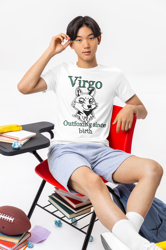 Young man sitting on a red classroom chair wearing a white Bella + Canvas Virgo Outfoxing Since Birth t-shirt.
