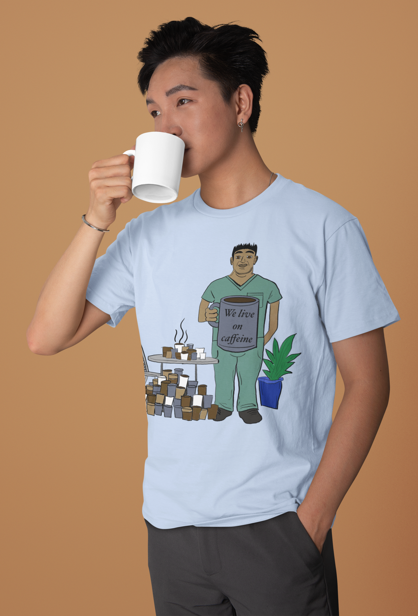 Asian man drinking coffee wearing baby blue We Live on Caffeine t-shirt – funny vet med apparel by GrungePup Vet Chaos