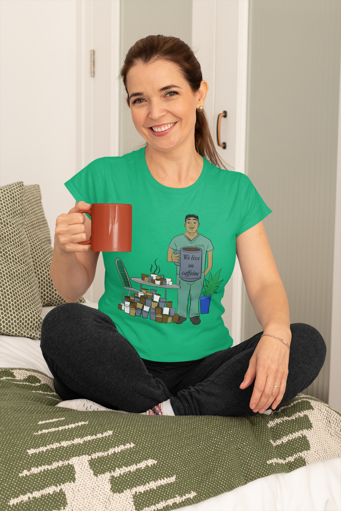 Middle-aged woman wearing heather kelly We Live on Caffeine t-shirt holding red coffee mug – sarcastic vet med humor by GrungePup Vet Chaos
