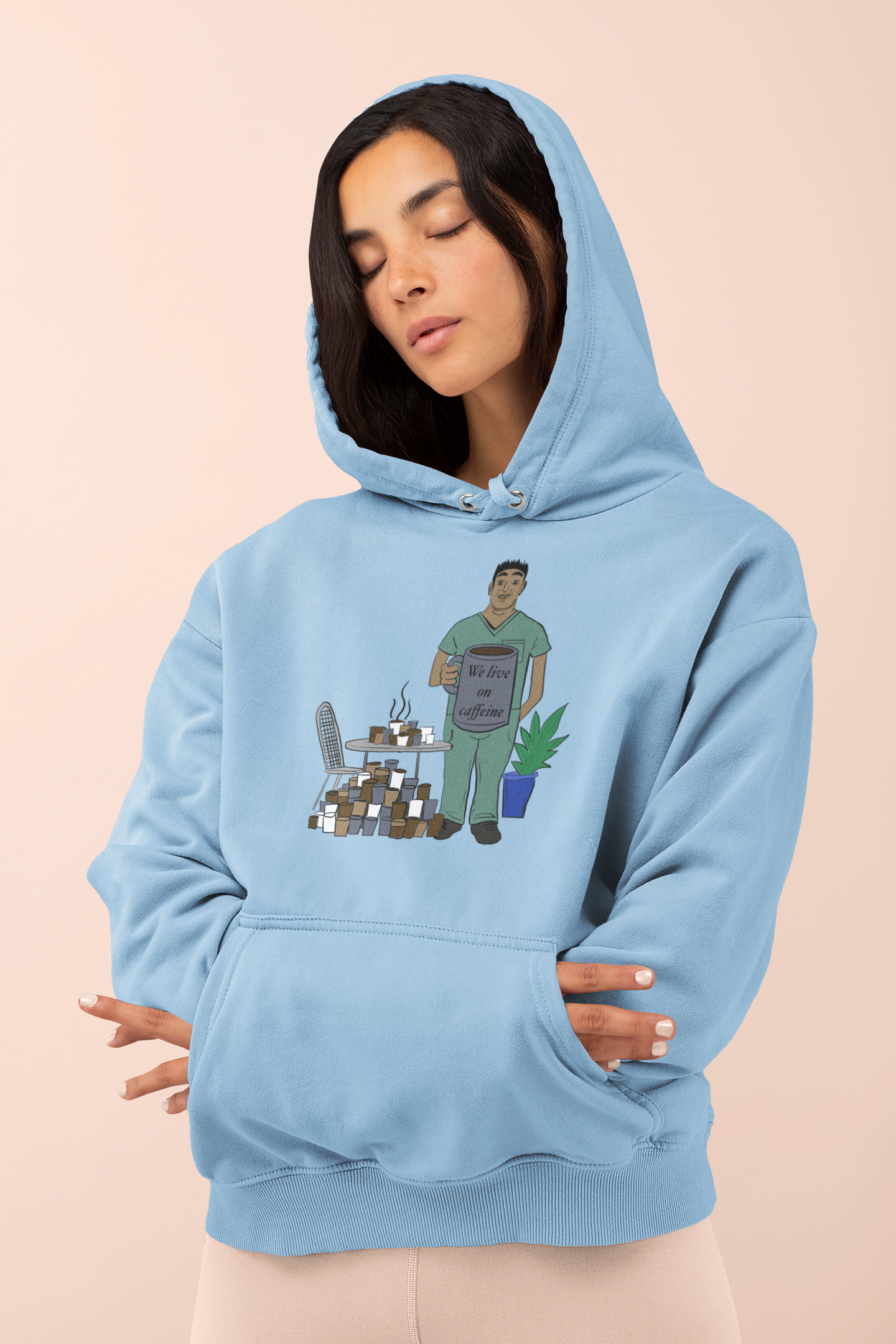 Woman wearing light blue "We Live on Caffeine" hoodie with vet tech and coffee illustration – GrungePup Vet Chaos burnt-out vet med humor