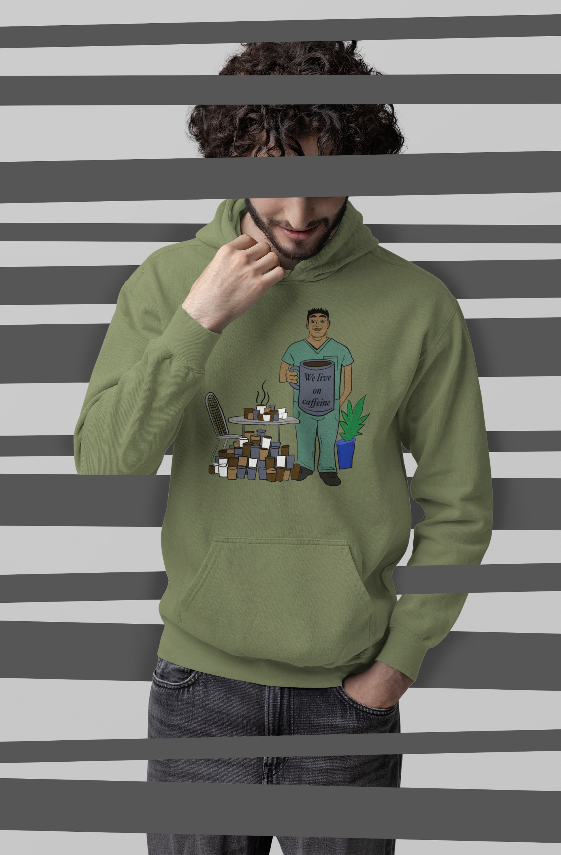 Man wearing military green "We Live on Caffeine" hoodie with vet tech holding giant coffee mug – GrungePup Vet Chaos sarcastic veterinary apparel