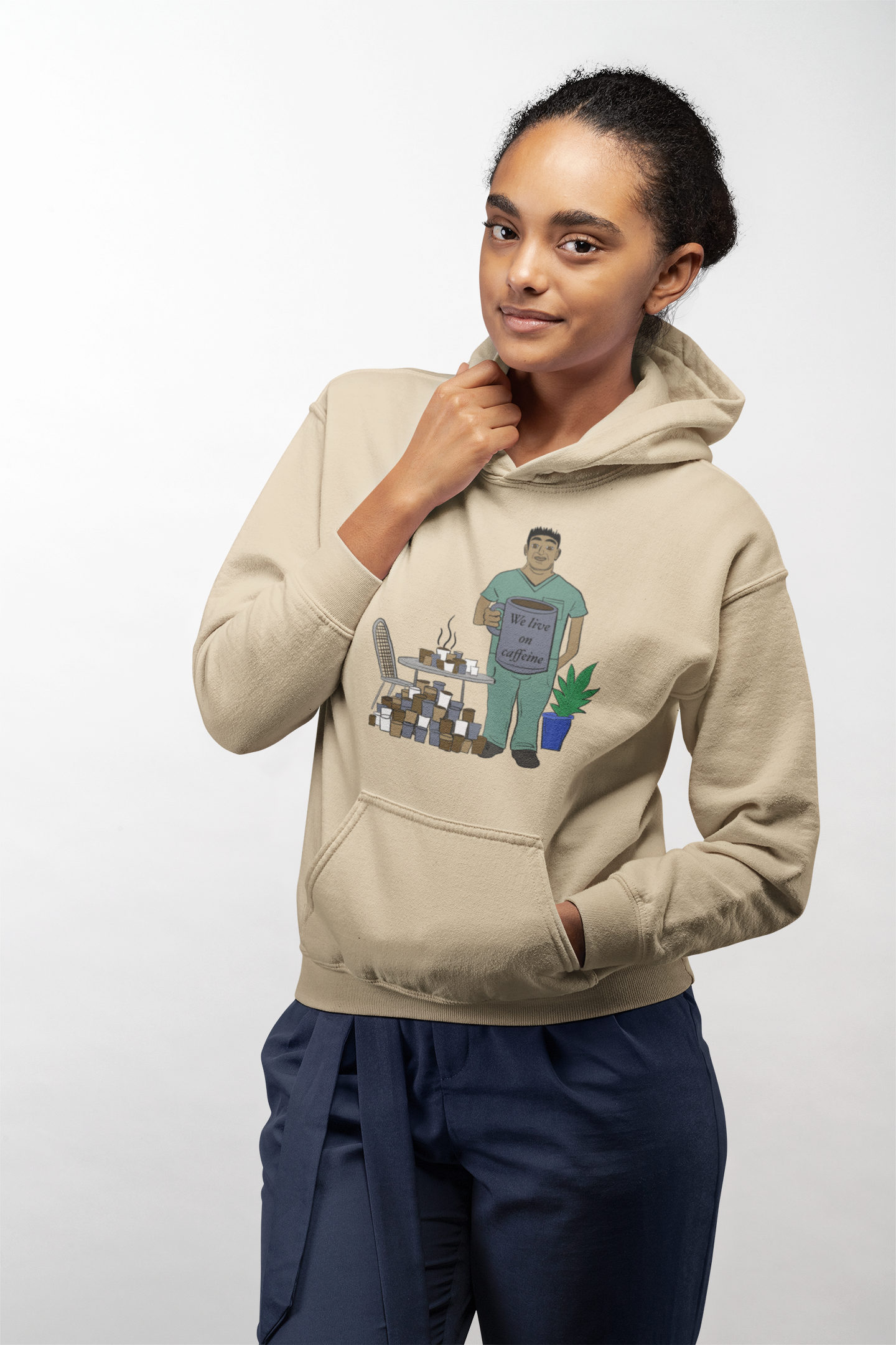 Woman wearing sand "We Live on Caffeine" hoodie with vet tech holding coffee mug and coffee cup pattern – GrungePup Vet Chaos funny vet tech apparel