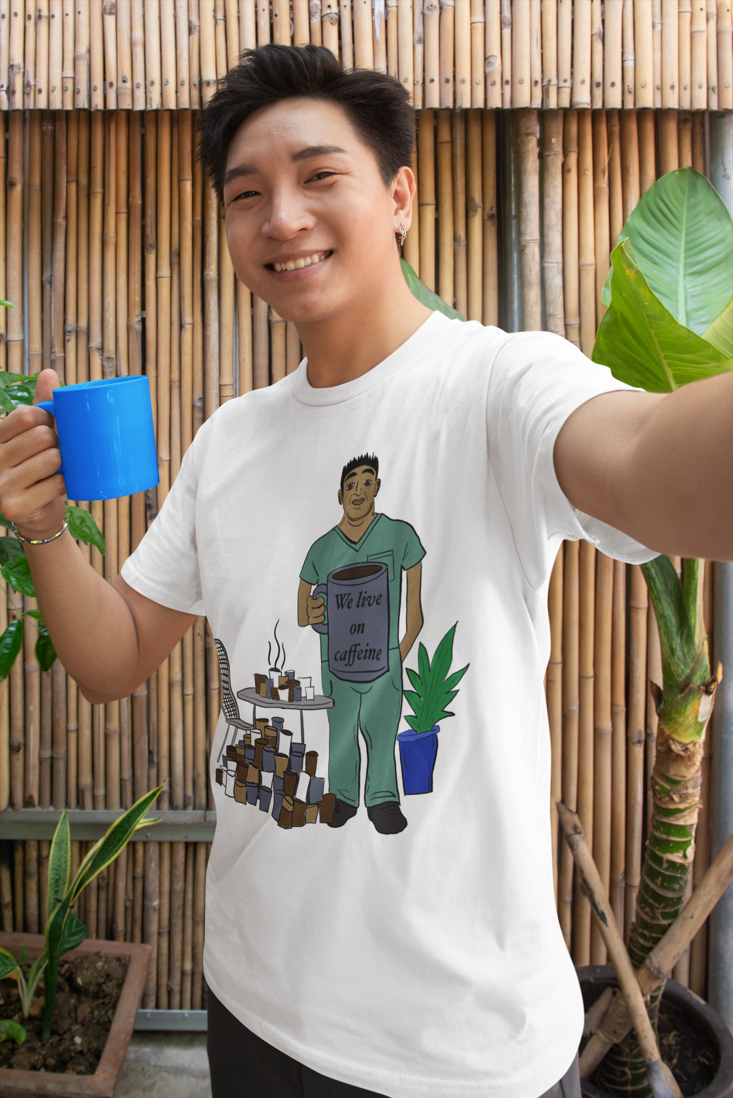 Asian man taking selfie wearing white We Live on Caffeine t-shirt holding blue coffee mug – sarcastic caffeine vet tech shirt by GrungePup Vet Chaos