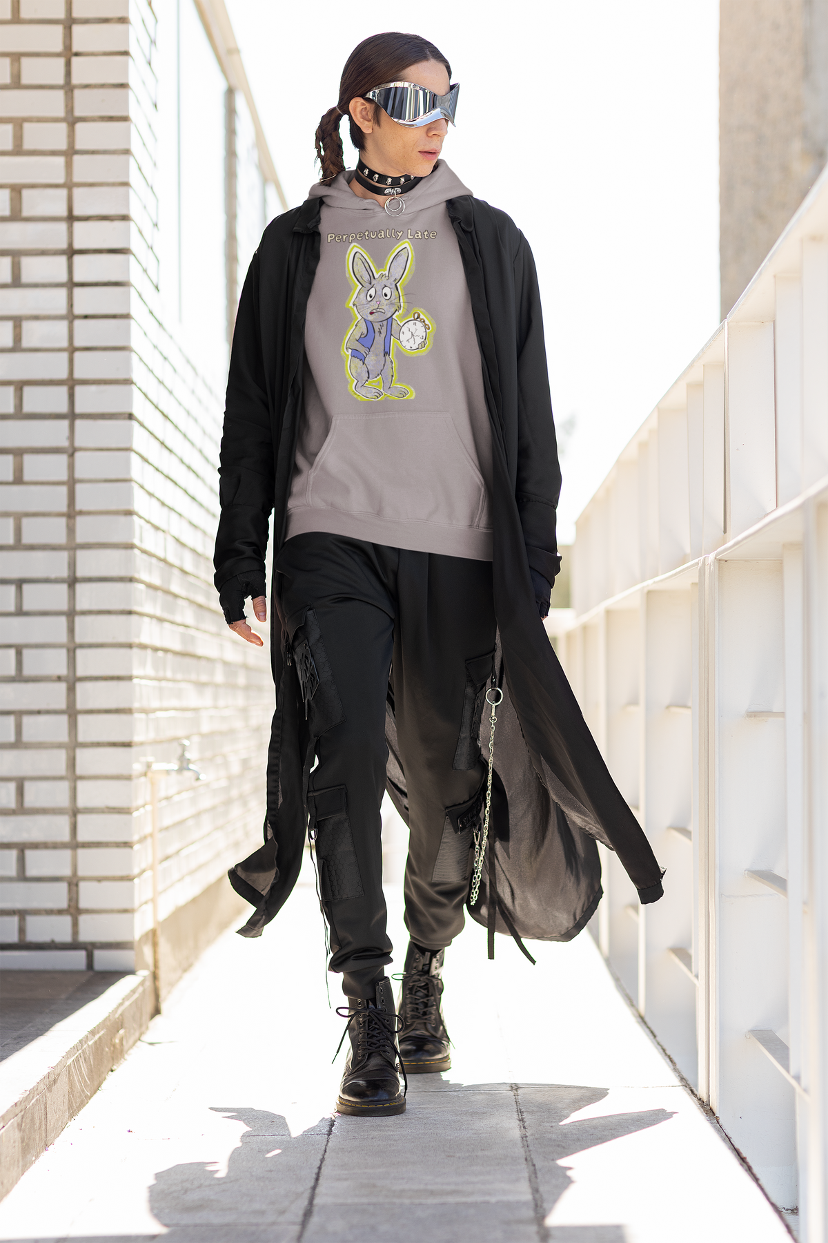 Person walking an outdoor corridor in a sport grey White Rabbit Perpetually Late hoodie, black coat, and combat boots. GrungePup That Girl, Alice.