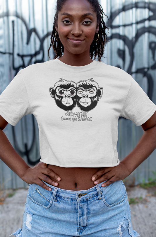 Woman standing confidently with hands on hips wearing a white cropped tee featuring the black and white Gemini monkey design