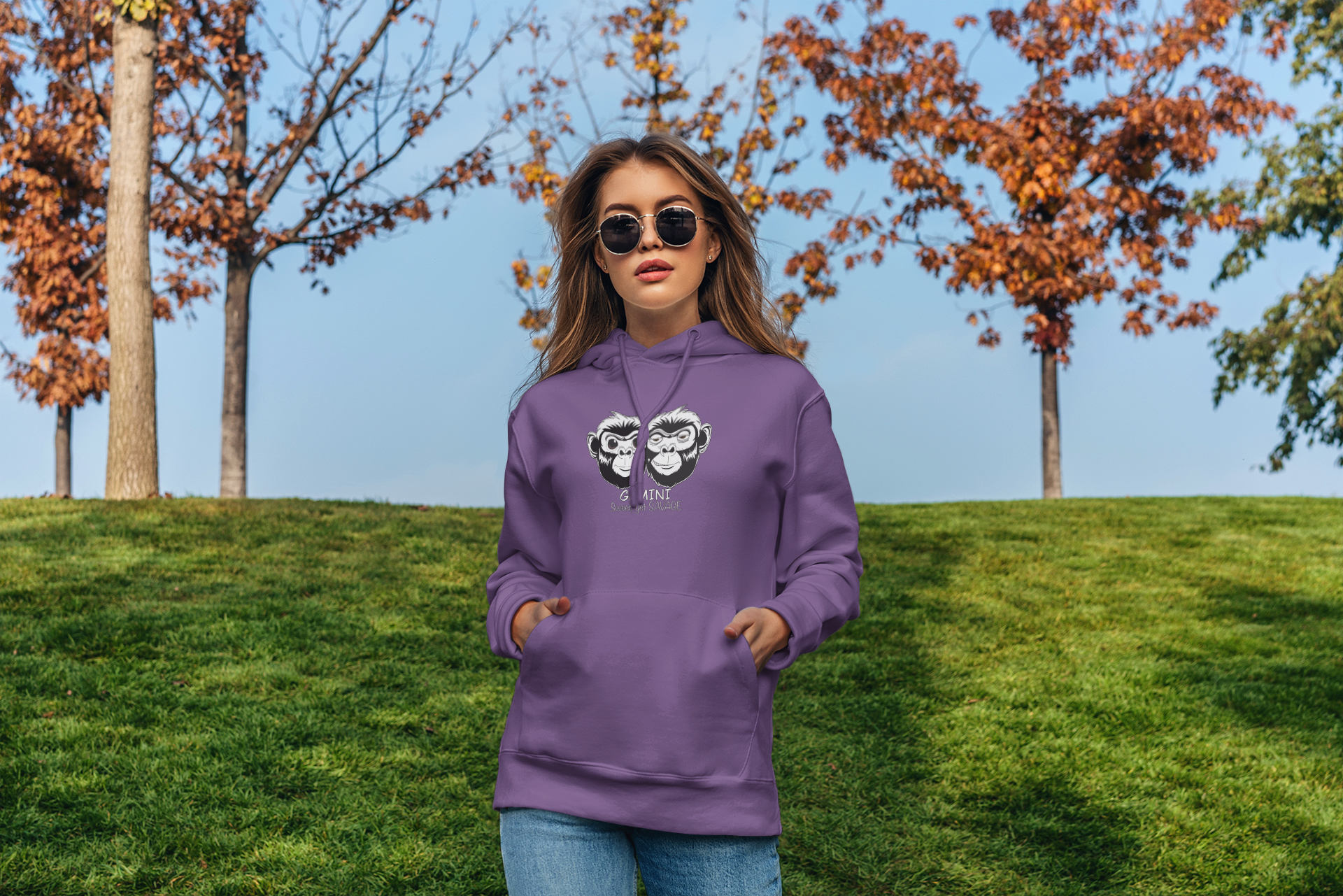 Woman standing confidently outdoors wearing a purple Cotton Heritage Gemini hoodie