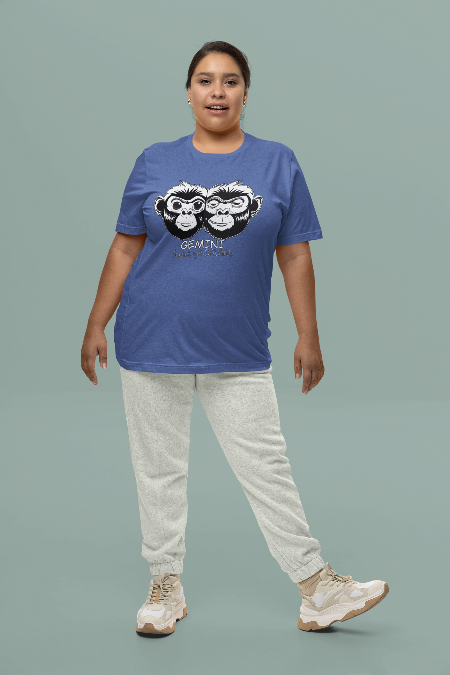 Woman standing in studio wearing a heather true royal Bella + Canvas Gemini monkey t-shirt