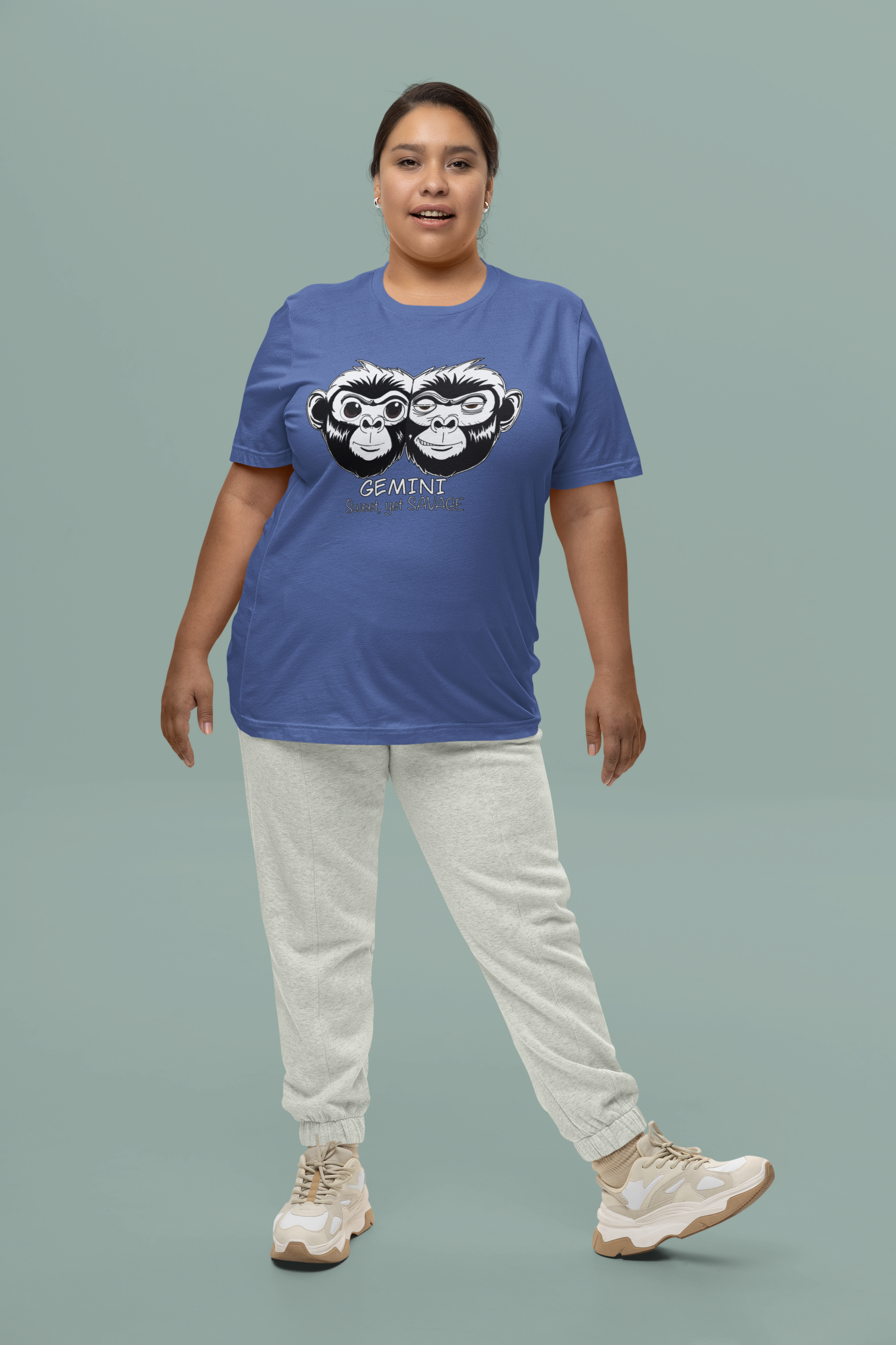 Woman standing in studio wearing a heather true royal Bella + Canvas Gemini monkey t-shirt