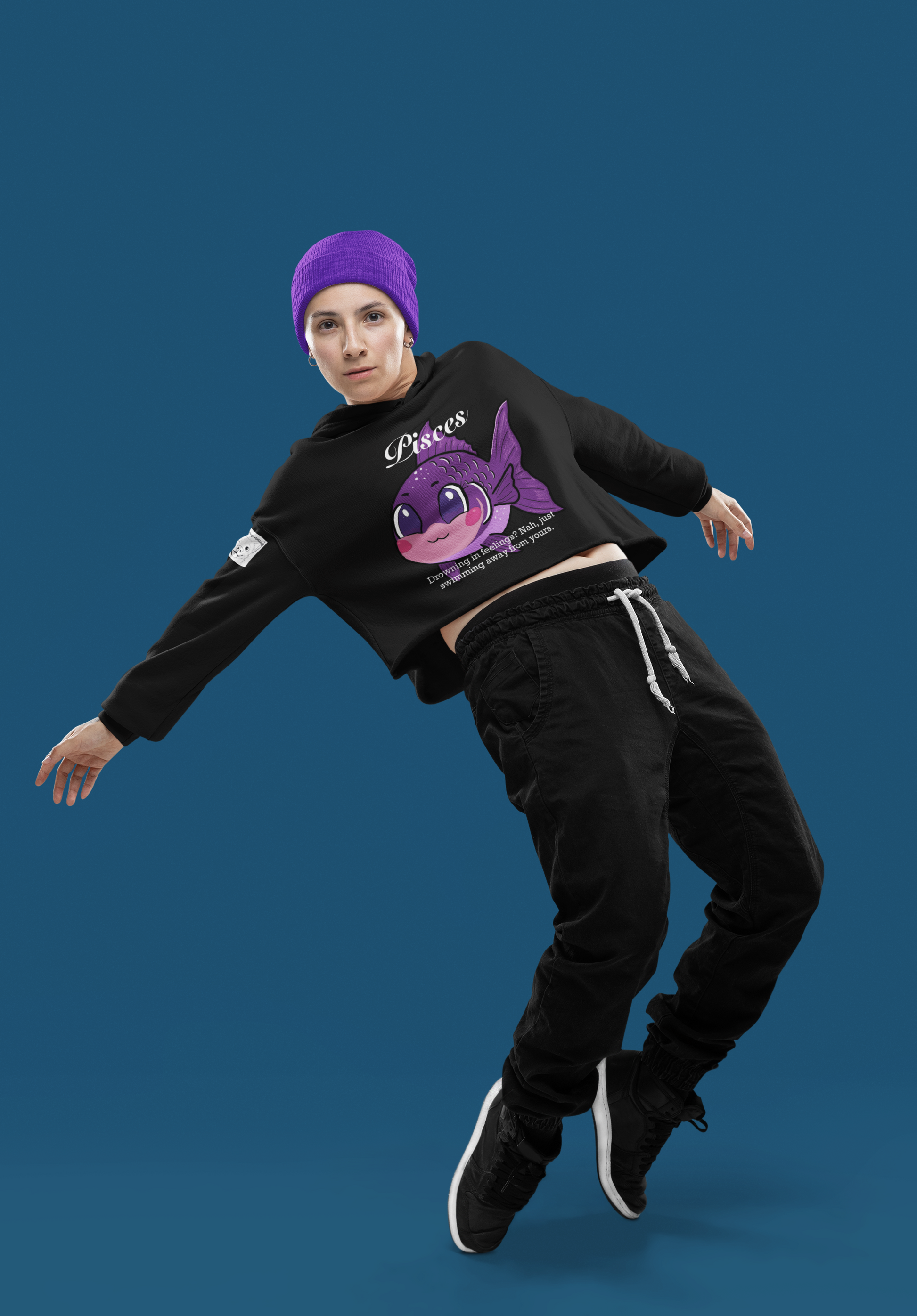 Woman in black athletic outfit dancing while wearing a black Pisces cropped hoodie