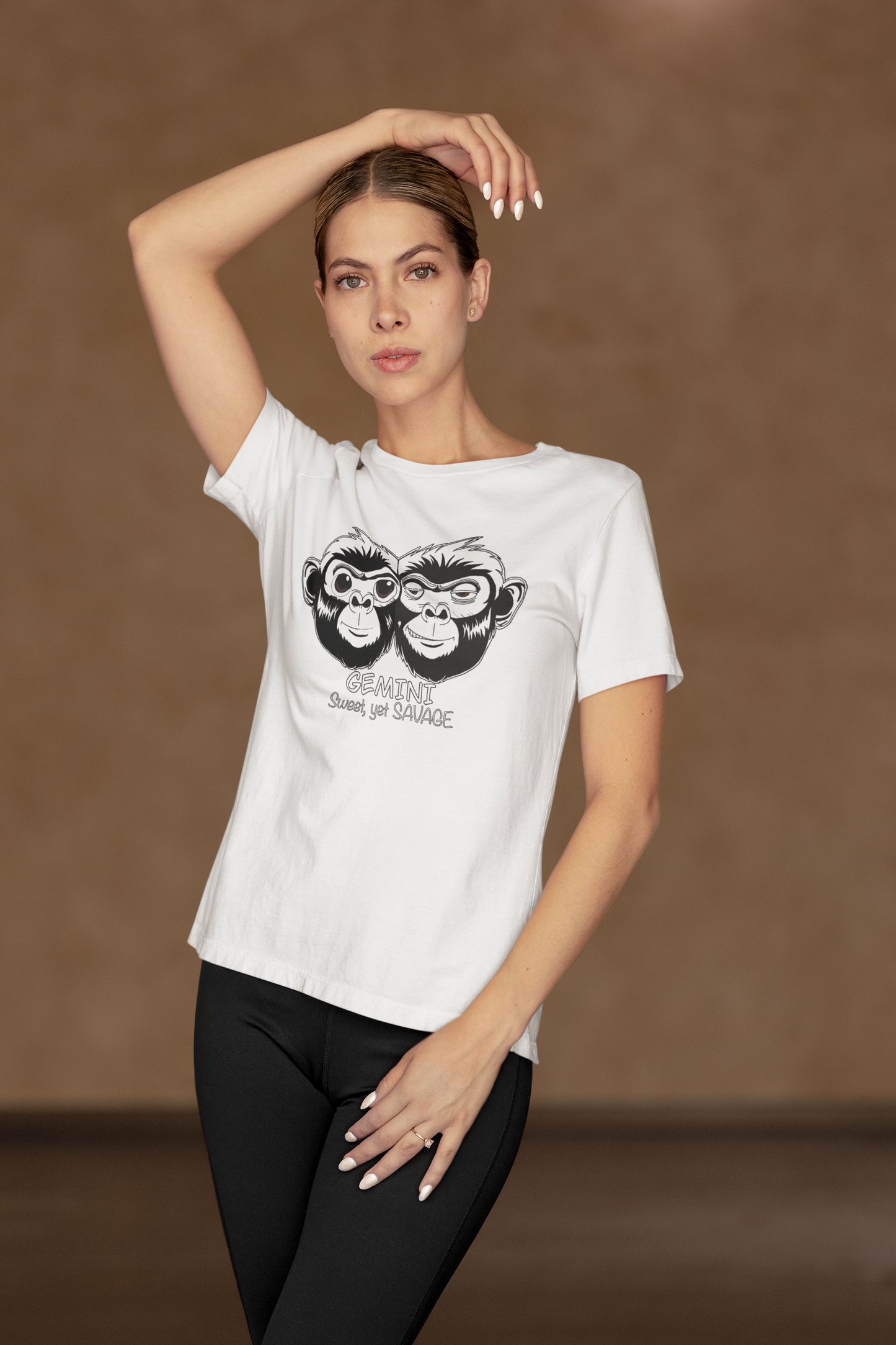 Woman in activewear posing with hand on head while wearing a white Bella + Canvas t-shirt featuring the Gemini monkey design