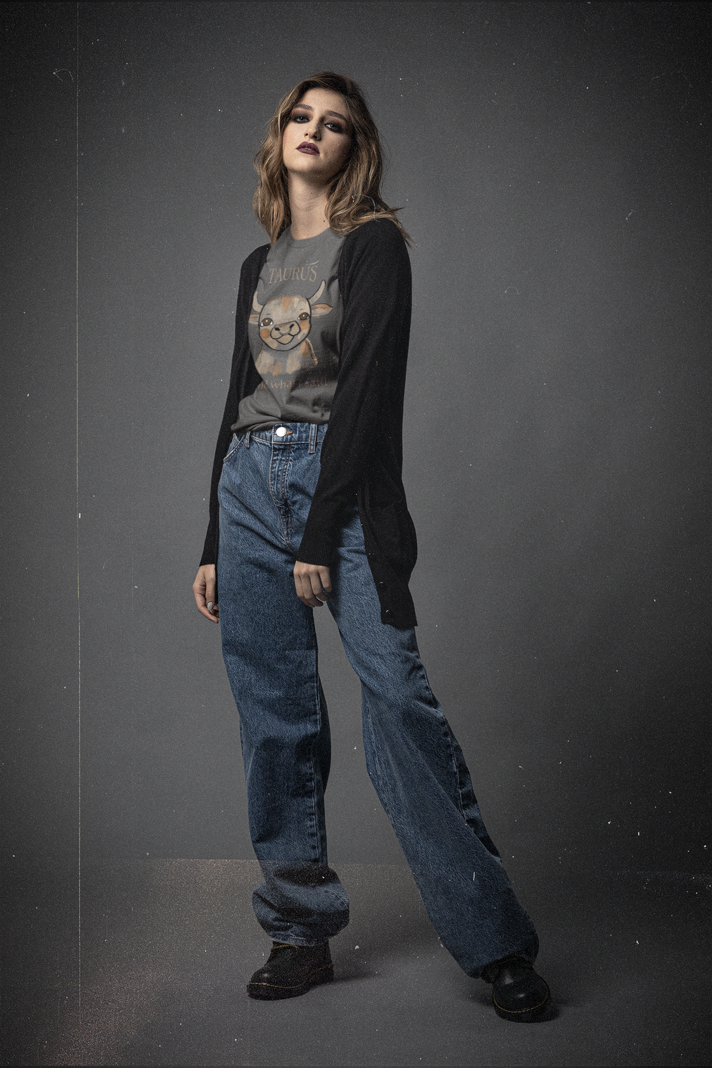 Woman in black cardigan and jeans wearing an asphalt gray Taurus Bull t-shirt