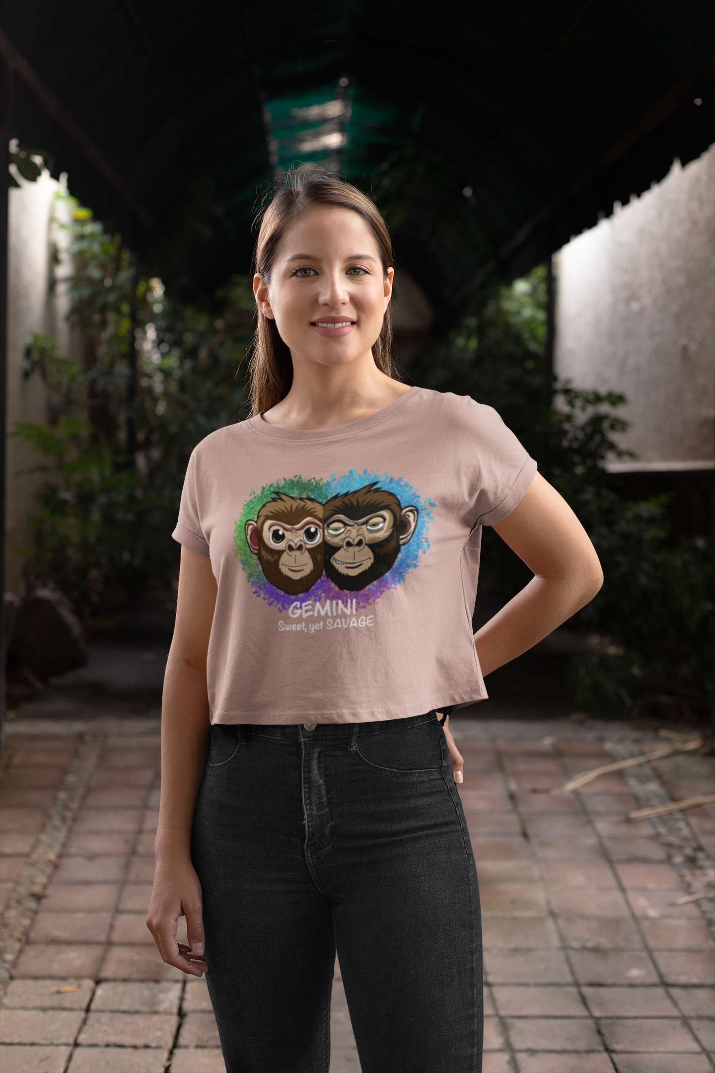 Smiling woman wearing a hazy pink Gemini Sweet yet SAVAGE cropped t-shirt with hand on hip outdoors
