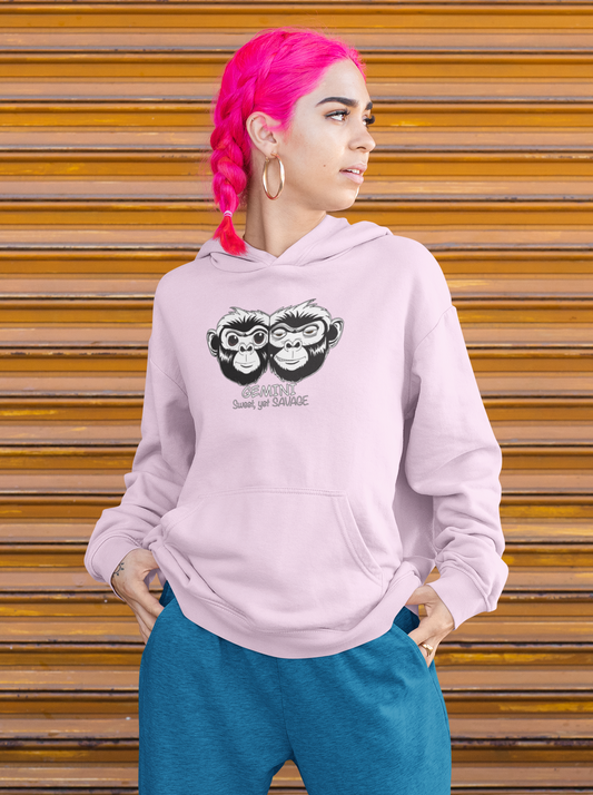 Woman with bright pink hair wearing a lavender cropped hoodie featuring the Gemini monkey design