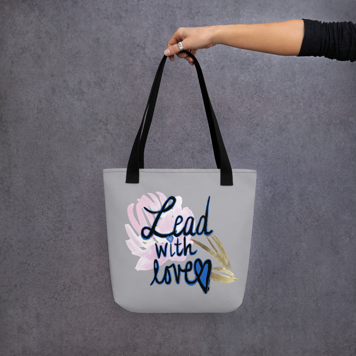 Back view of a plain grey tote bag with black straps and no print.