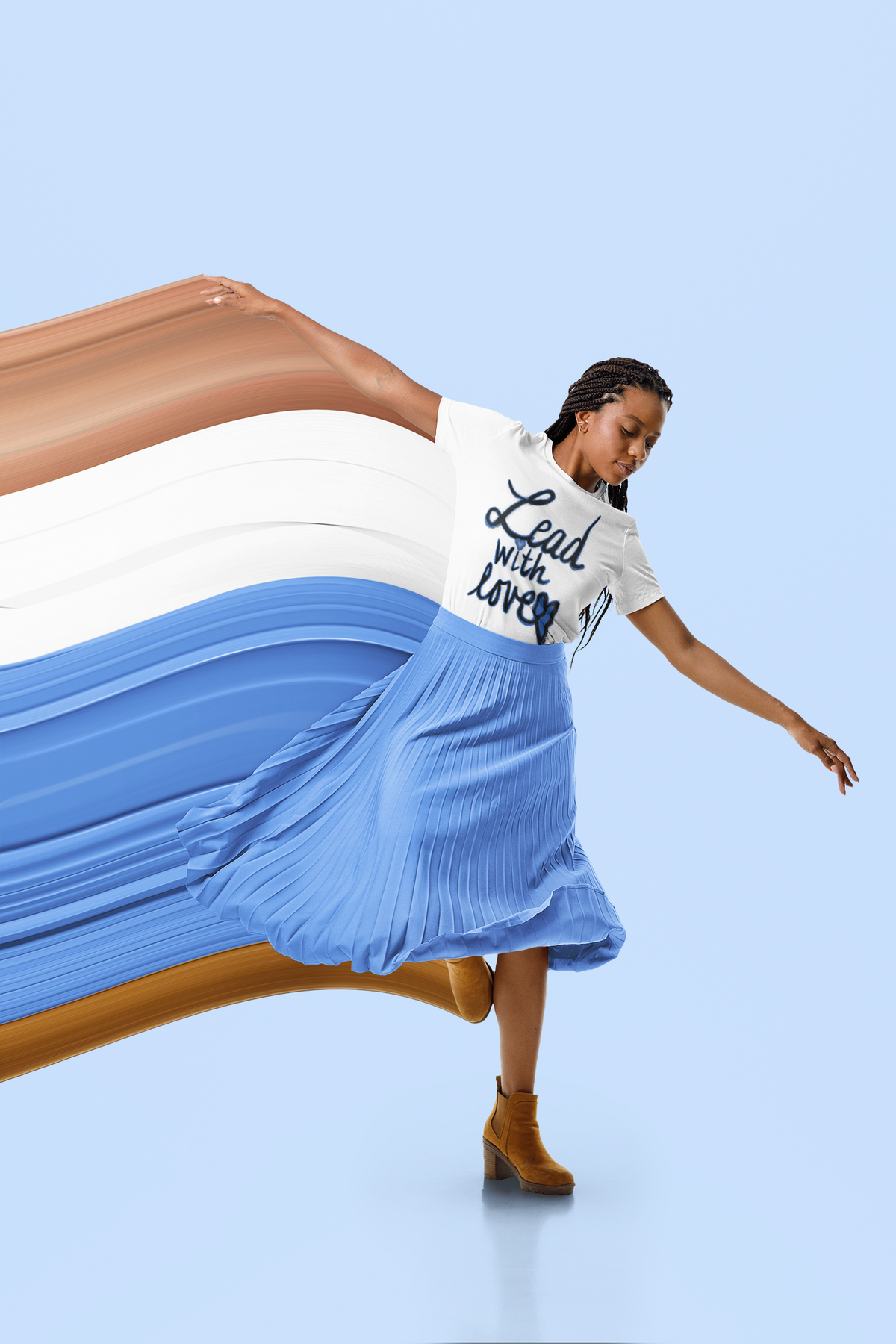 Woman with braids in a white Lead with love tee and a blue pleated skirt leans into a turn, arms out, on a pale blue background.